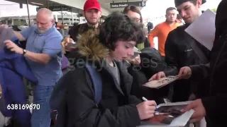 Finn Wolfhard giving autographs to his fans at the LAX Airport.