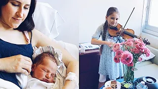 Newborn baby is enjoying sister's violin playing at the hospital