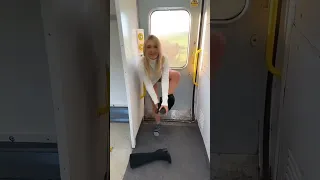 Dentro del tren una mujer se saca sus botas y con sus calcetas puestas bailando