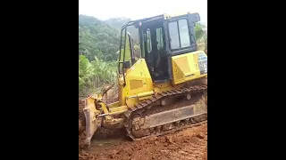 Komatsu D51EX Bulldozer Scrapes Soil for Plantation Road Access