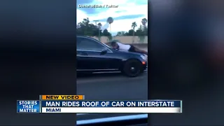 Man caught on video riding on hood of car on freeway