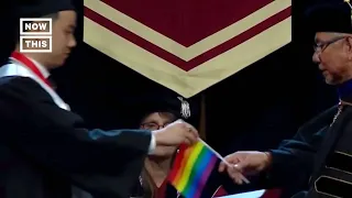 Graduates Hand Pride Flags to University President