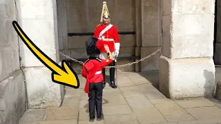 Cute Little boy dressed as Royal Guard salutes the King's Guard.