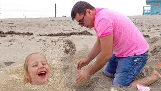 Stacy e papai brincam no mar na areia