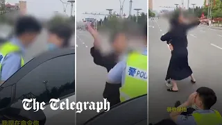 China's Covid lockdown: Police officer pushes woman to ground as she tries to get father's medicine