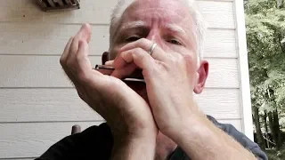 old man playing blues harmonica on back porch in Mississippi