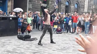 Street artist swallows a sword and juggles knives