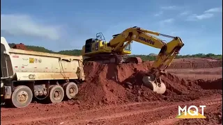 Escavadeira Komatsu PC 500 no carregamento da caçamba volvo FMX 8x4