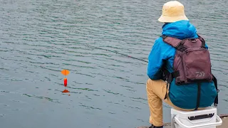 A man uses small fish as bait to catch big fish.