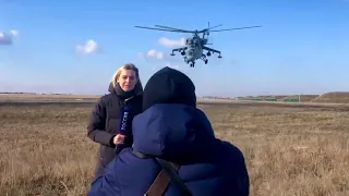 Dangerous Mi-24 Hind Attack helicopter passes over the reporter's head.