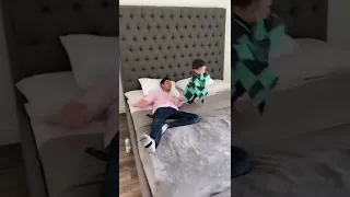 Father and son doing stunts in bed and mom see's it .