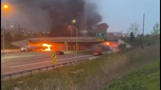 Traffic flows past as tractor-trailer burns under overpass on I-95