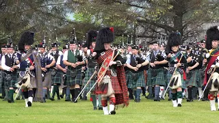 Massed Pipe Bands march for the opening of the 2019 Dufftown Highland Games in Moray Scotland