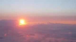 Sunrise above clouds from plane to Spain