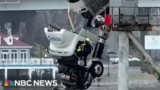 Dramatic rescue as truck dangles from bridge