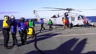 Colourful jerseys on a warship’s flight deck