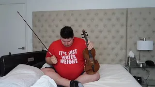 nikocado playing the violin on his bed