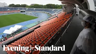 Olympic flame arrives in soggy Tokyo in front of empty stadium