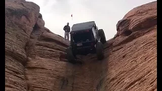 Jeep climbs up near vertical rock in Utah