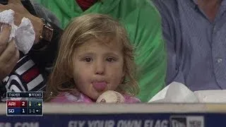 A young fan licks a baseball