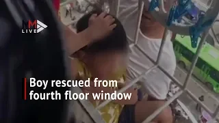 Firefighters rescue boy dangling from fourth-floor window