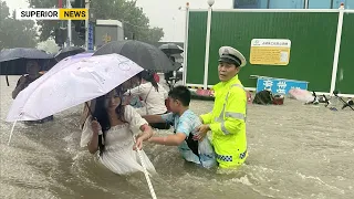 Officers help a resident in the middle of heavy rain