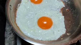 Cooking sunny side up eggs in a stainless steel pan