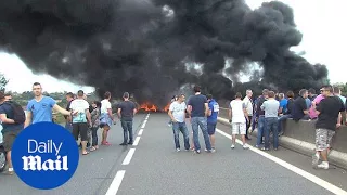 Striking ferry workers burn tyres to block road in Calais - Daily Mail