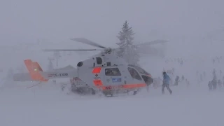 Rescue Helicopter creating a snowstorm during takeoff from Snow-Space Flachau