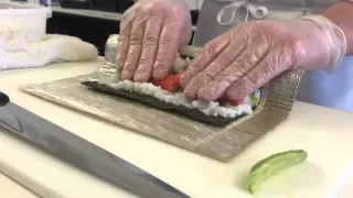 A sushi chef's demonstration of the technique for making a California roll