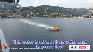 Water  bombers fill up water next to cruise liner