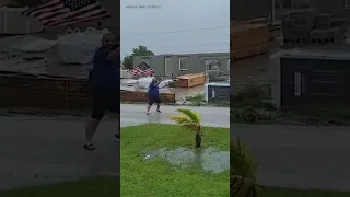 Man holds up U.S. flag amid strong winds ahead of Hurricane Ian