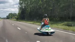 Man rides jet ski down a public road