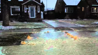 Water main break seeping through driveway into street