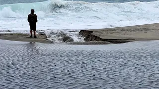 Heavy Rain Leads to River Breaching Sand Berm