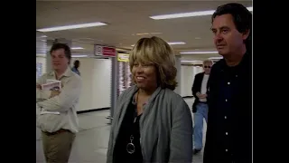 Tina Turner jokes with photographers at Heathrow Airport