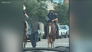Texas police on horseback lead walking handcuffed man by a rope