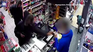 Terrifying moment armed robbers pull a gun on a cashier