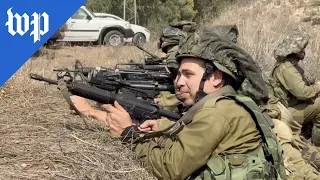 Israeli soldiers clear bodies after attack in Kfar Azza