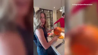 Jennifer Aniston carves a Halloween pumpkin with Sandra Bullock