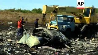 Crane lifts sections of plane wreckage as serach of crash site continues