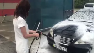 Прекрасная девушка моет свой автомобиль
