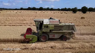 Harvest 2022: Claas Dominator 88s combine and Rollant 46 baler harvesting wheat in Suffolk