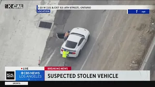 Stolen vehicle chase ends with suspect and a bystander pushing the car down a freeway offramp
