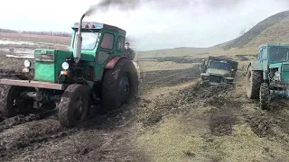 Трактора пытаются вытащить застрявшие грузовики.