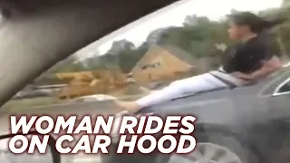 Woman rides on car hood down Houston highway