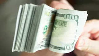 Caucasian hands holding and checking a stack of hundred us dollar banknotes