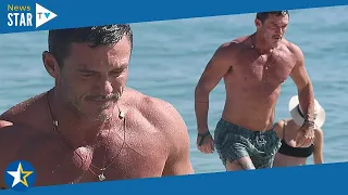 Luke Evans showcases his washboard abs and bulging pecs as he goes for a shirtless swim in Miami 295