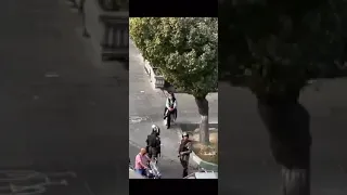 mujer iraní sin pañuelo ante los antidisturbios, mientras suena “El pueblo unido jamás será vencido”