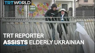 TRT journalist helps an elderly Ukrainian during the evacuation